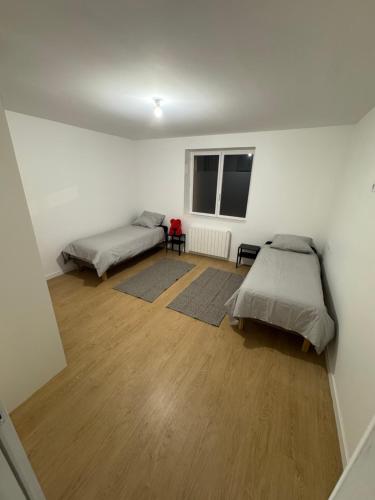 Cette chambre dispose de deux lits et de parquet. dans l'établissement T3 10 min de aeroport St exupery plein centre ville, à La Verpillière