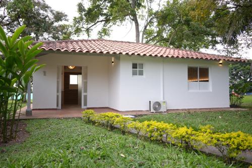 a white house with a door and a yard at Hotel Barranqueros Soledén in Armenia