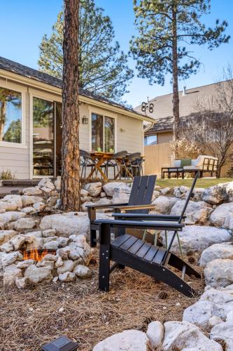 a patio with a table and chairs and a stone wall at Cozy 4BR Near Ski Resort - Firepit & Pool Table in Flagstaff