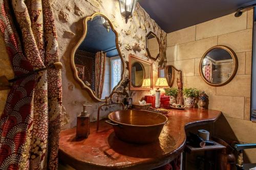 a bathroom with a sink and a large mirror at Le Spa du Sorcier in Longeville-lès-Metz