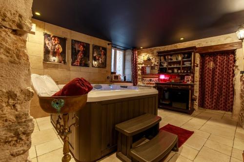 a large kitchen with a tub and a sink at Le Spa du Sorcier in Longeville-lès-Metz