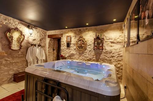 a large bathroom with a tub in the middle of it at Le Spa du Sorcier in Longeville-lès-Metz