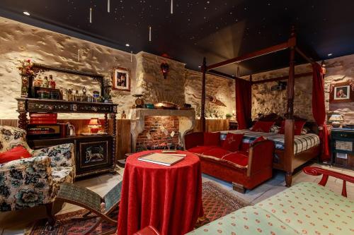 a bedroom with a bed and a fireplace and a table at Le Spa du Sorcier in Longeville-lès-Metz