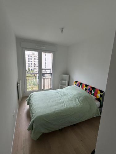 une chambre blanche avec un lit et une fenêtre dans l'établissement Appartement calme et lumineux avec 2 chambres et un parking, à Saint-Ouen