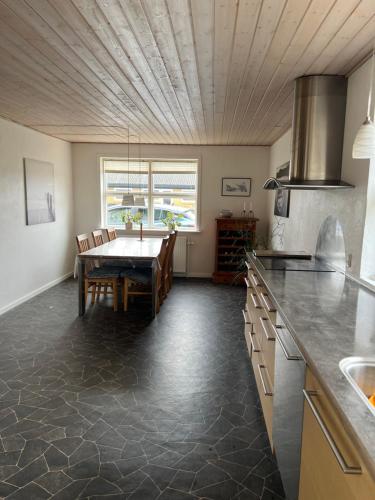 a kitchen with a table and a dining room at Dejlig og hyggelig hus i Thyborøn in Thyborøn