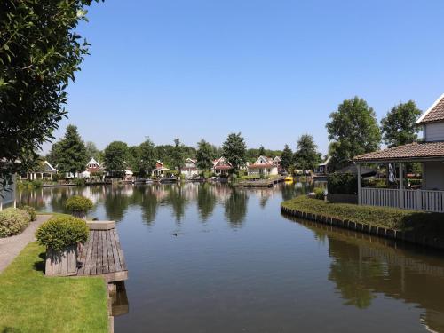 a river with a bunch of houses on it at Bungalow in Zuytland Buiten with Fishing Platform in Simonshaven