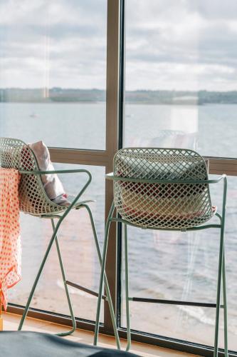 two chairs sitting in front of a window at Le Chantier d 'Ernest- Loft T4 les pieds dans l' eau in Carantec