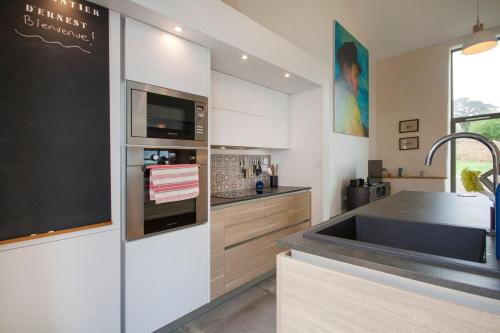 a kitchen with a sink and a counter top at Le Chantier d 'Ernest- Loft T4 les pieds dans l' eau in Carantec