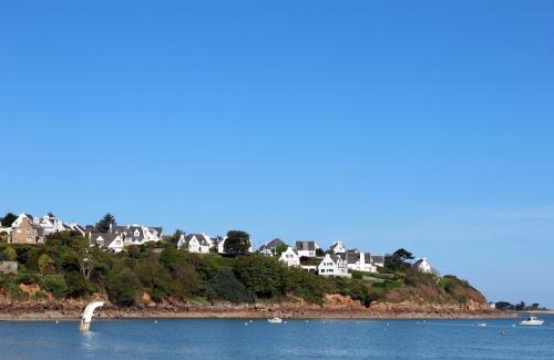 a group of houses on a hill next to the water at Le Chantier d 'Ernest- Loft T4 les pieds dans l' eau in Carantec