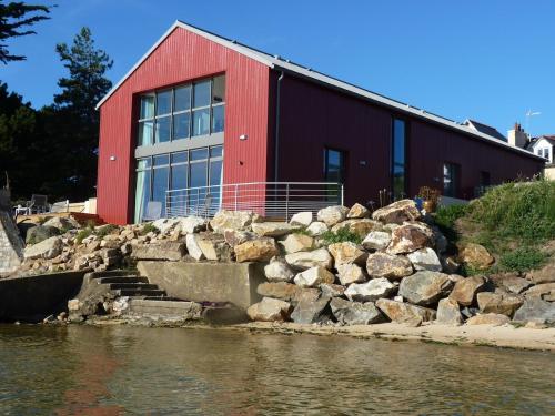 a red building next to a body of water at Le Chantier d 'Ernest- Loft T4 les pieds dans l' eau in Carantec