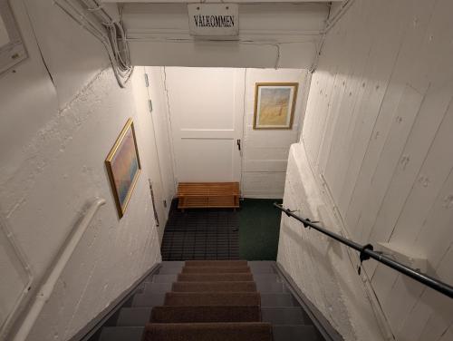 a hallway with stairs and a white door and a sign at Prisvärt semesterboende in Vadstena
