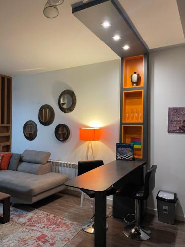 a living room with a table and a couch at 7 Studio Apartment in Pristina