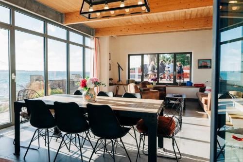 a dining room with a table and chairs at Le Chantier d 'Ernest- Loft T4 les pieds dans l' eau in Carantec