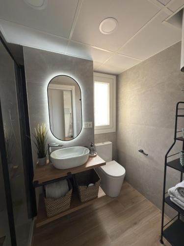 a bathroom with a sink and a toilet and a mirror at Apartamento La Gata del Cabo in El Cabo de Gata