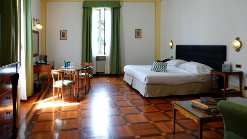 a hotel room with a bed and a table and chairs at Hotel Villa La Bollina in Serravalle Scrivia