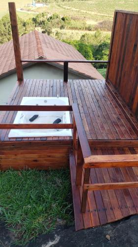 a wooden bench sitting on top of a deck at Chale bela vista paraisopolis mg in Paraisópolis