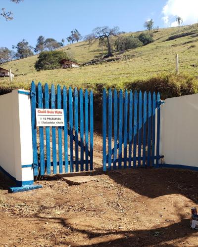 a blue fence with a sign in front of it at Chale bela vista paraisopolis mg in Paraisópolis