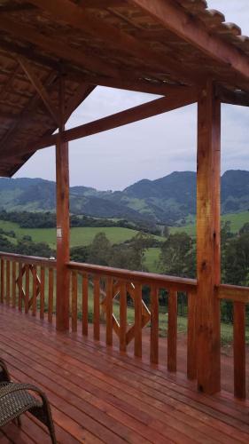 a wooden deck with a view of the mountains at Chale bela vista paraisopolis mg in Paraisópolis