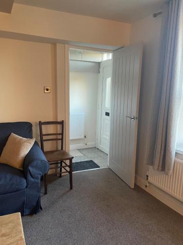 a living room with a blue couch and a chair at Willden Cottage in Holmfirth