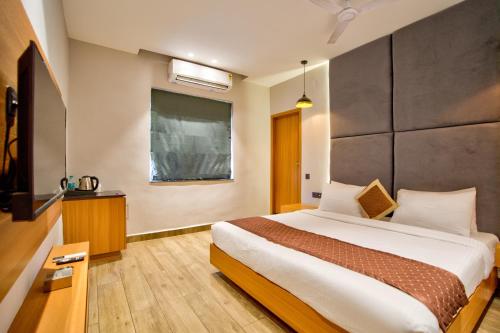 a bedroom with a large bed and a television at The Beach House Candolim in Candolim