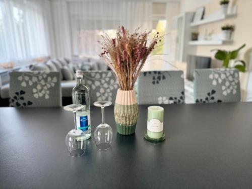 a table with a bottle and glasses and a vase at Refugium 2020 in Marienheide