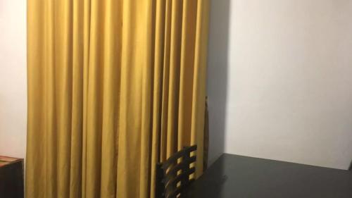 a yellow curtain in a room with a table at Bracedale Estate in Kegalle