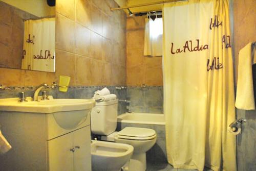 y baño con lavamanos y cortina de ducha.  en Cabanes La Aldea Mar de las Pampas en Mar de las Pampas