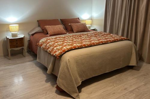 a bedroom with a large bed with two lamps on it at Chatimbarbe in Yssingeaux