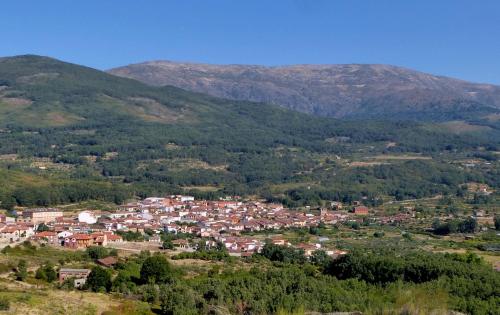 a town in a valley with mountains in the background at Apartamentos Rurales Entre Fuentes in Cuacos de Yuste