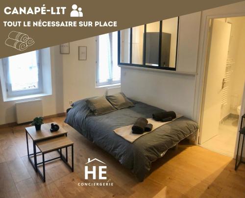 a large bed in a room with a table at Room 203 Hyper Proche Gare 250m in Montargis