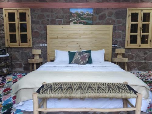 a bedroom with a large bed with a wooden headboard at Auberge laurier rose in Ourika