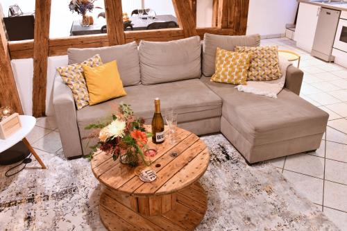 - un salon avec un canapé et une table avec une bouteille de vin dans l'établissement Gite See You Soon - Studio Fun, à Colmar