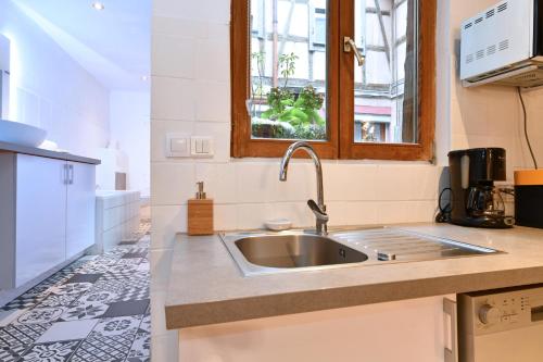 una cucina con un lavandino e una finestra di Gite See You Soon - Studio Fun a Colmar