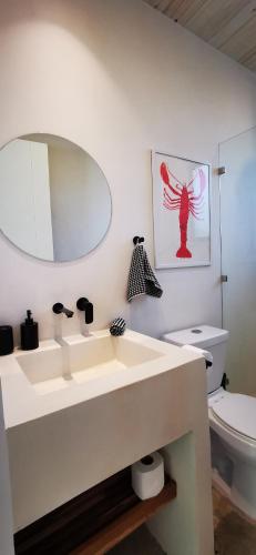 a bathroom with a white sink and a toilet at Casa Remy - Walk to the Beach and stay in a private compound! Pool, Kitchen, AC, Wi-Fi in Mal País