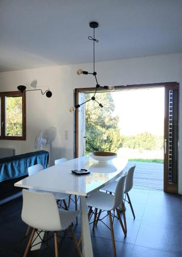 une salle à manger avec une table et des chaises blanches dans l'établissement Havre de paix à 10 minutes de la mer et 15 minutes d'Ajaccio, à Appietto