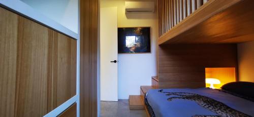 a bedroom with a bed and a stairway with a stair at Casa Remy - Walk to the Beach and stay in a private compound! Pool, Kitchen, AC, Wi-Fi in Mal País