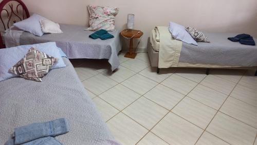 una stanza con due letti e pavimento piastrellato di Sossegoterapia a Casa Branca