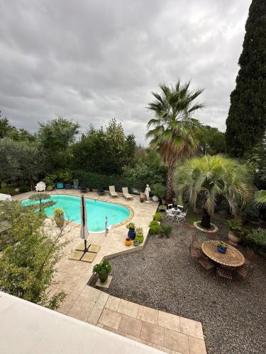 une vue aérienne d'une piscine dans un jardin dans l'établissement L'Esquisse en Rose - Parking Clim Netflix Canal, à Milhaud