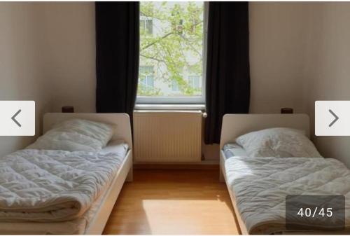 two beds in a room with a window at Monteurwohnung bei Nina 1OGL in Zeitz