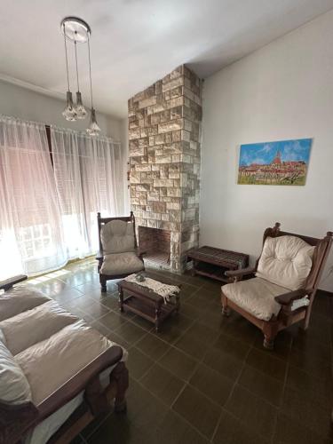 een woonkamer met een bed en een stenen open haard bij Casa en Villa Carlos Paz in Villa Carlos Paz