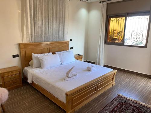 a bedroom with a bed with white sheets and a window at Villa Soufia in Marrakech