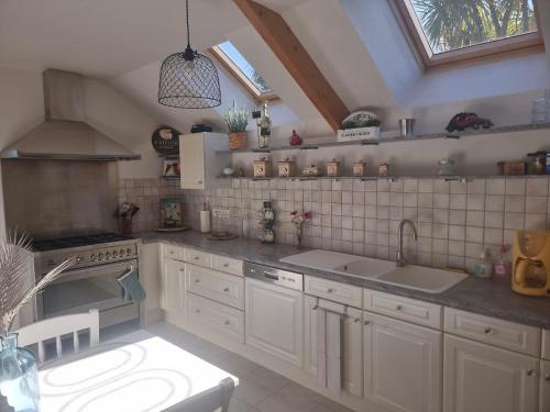 a kitchen with a sink and a stove top oven at La Verte Colline in Siouville