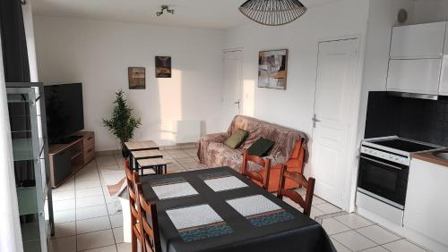 un salon avec une table et une chaise dans l'établissement Appartement, entrée autonome, à proximité de la gare, à Le Theil-de-Bretagne
