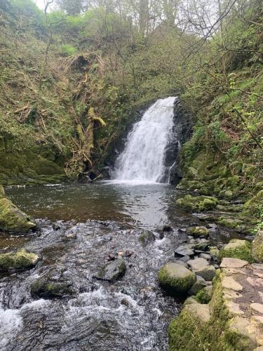 a waterfall in the middle of a river at The Burrow in Glenoe