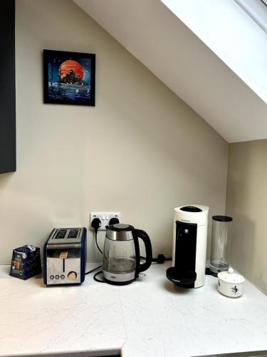 a kitchen counter with a coffee maker and a blender at The Burrow in Glenoe