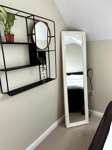 a mirror on a wall next to a bedroom at The Burrow in Glenoe