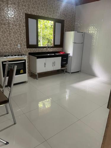 cocina blanca con nevera y fregadero en Casa da Jessica, en Paraty