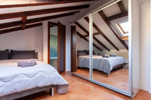Un dormitorio con dos camas y un espejo. en Heart of NoLo - Meryggiare Apartments, en Milán