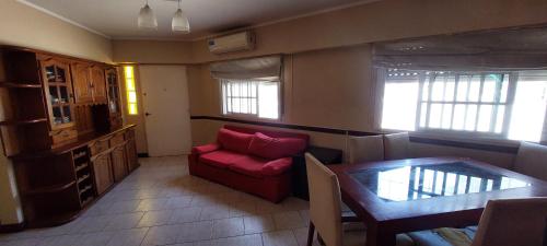a living room with a red couch and a table at Hermosa casa, parrilla, aire libre, 8 personas in Buenos Aires