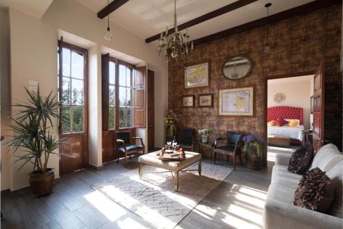 a living room with a brick wall at Hotel Boutique Casa del Jardín Aguascalientes in Aguascalientes